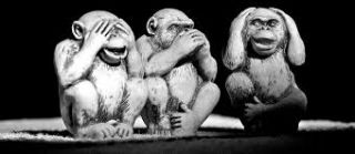 Black and white photo of statues of 3 monkeys, covering eyes, ears, and mouth.