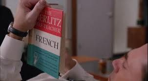 Caucasian man, reclining, reading Berlitz book (French)