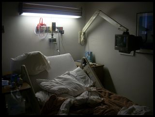 Empty hospital bed with disordered pillow and sheets. 