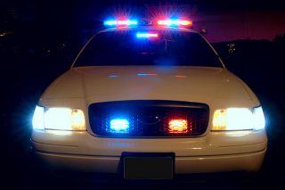 Police car with flashing blue and red lights. 