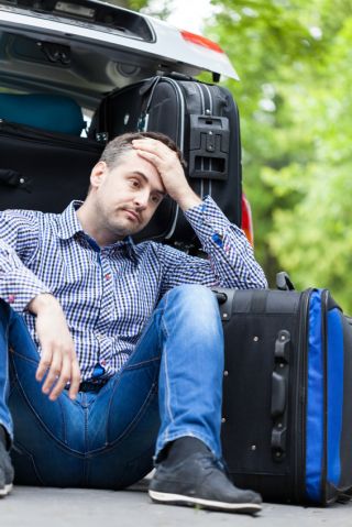 Stressed man taking a break by his luggage
