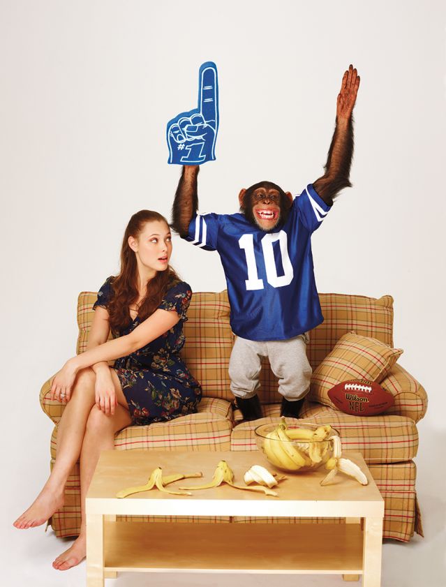  Chimp cheering for sports on a couch w/ human spouse watching