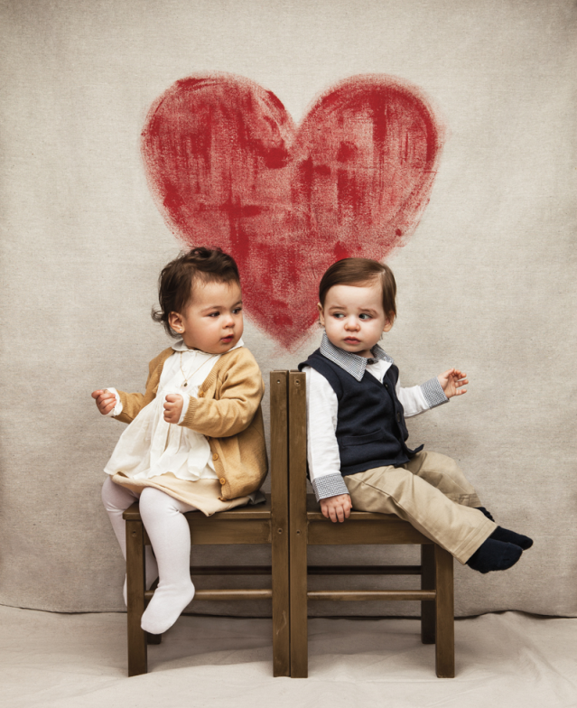 Baby boy and girl with heart above them