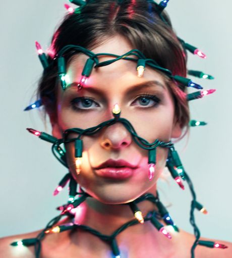  Young woman's portrait covered in christmas lights