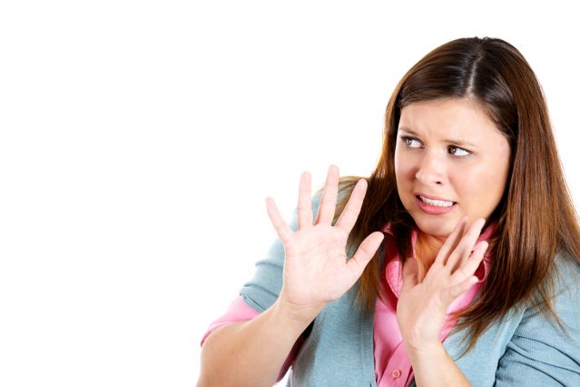 Woman holding up hands shying away from something