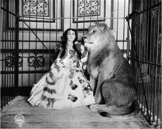 Madame Adjie Castillo with one of her lions in 1897. It was in this cage that a mother cat gave birth to kittens at the Circle Theatre. 