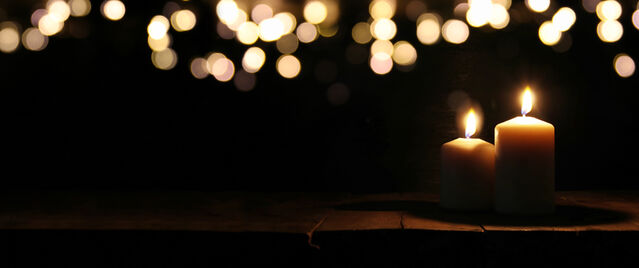 'tomertu/Adobe Stock', 'Burning candles over black background with bokeh glitter lights, licensed for use'.