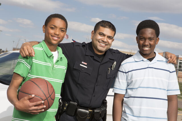 'Studio615/Adobe Stock', 'Policeman talking to kids on the street, licensed for use'.