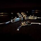 Image: Silver handcuffs with keys on black background